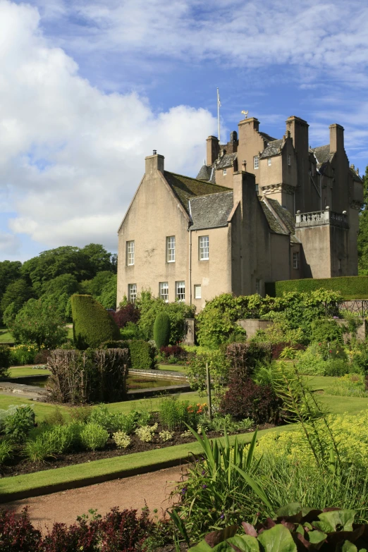 a house in the middle of a garden on a sunny day