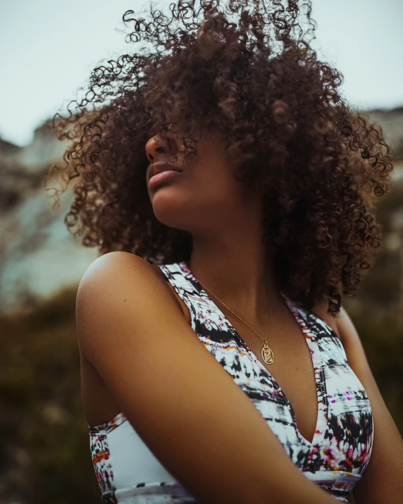 a woman is posing for a pograph with curly hair