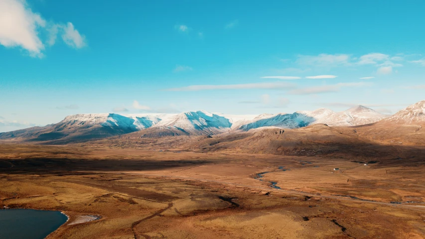 a wide open field with a mountain in the background