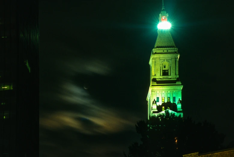 a lit up building in the night with some green lights