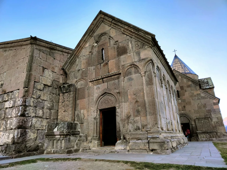 an old stone church stands tall as it has stained glass windows