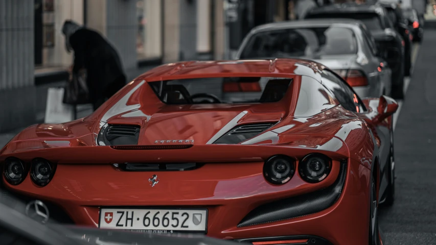 red sports car parked in street with another car next to it