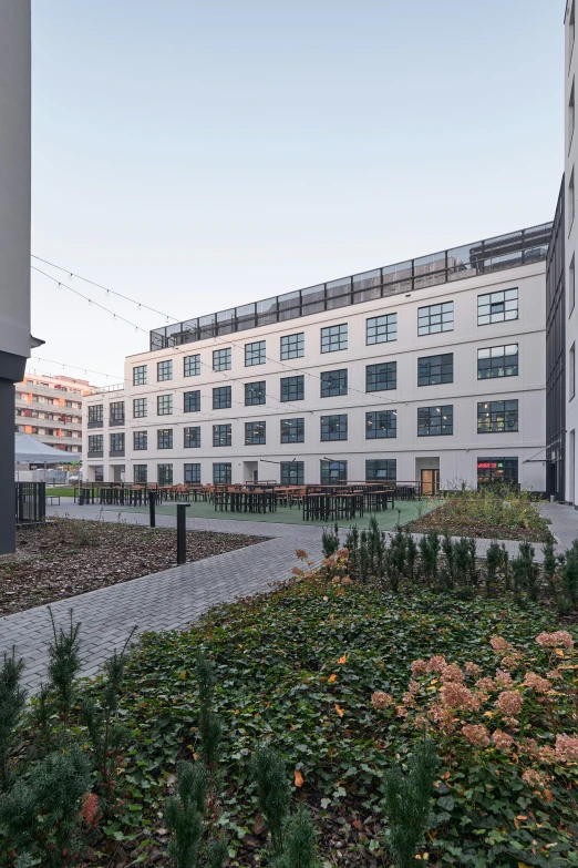 a white building with green plants growing on the walkway