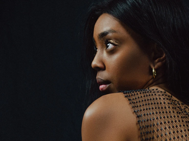 an african woman in gold earrings stares back at the camera