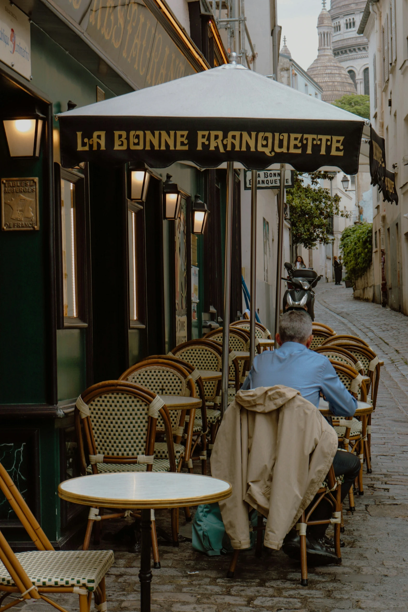 two men under a table with chairs near a sidewalk