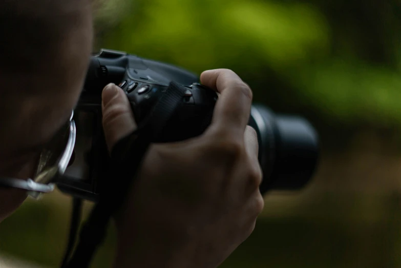 a man holds a camera up in front of his face