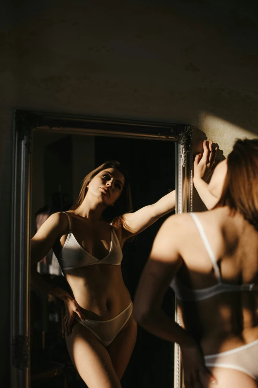 two women standing in front of a mirror and brushing their teeth