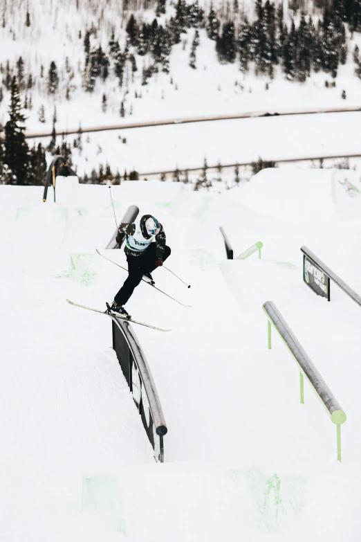 a snow skier is at the bottom of a rail