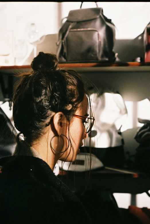 a woman talking on a phone in a room with a bag and purse