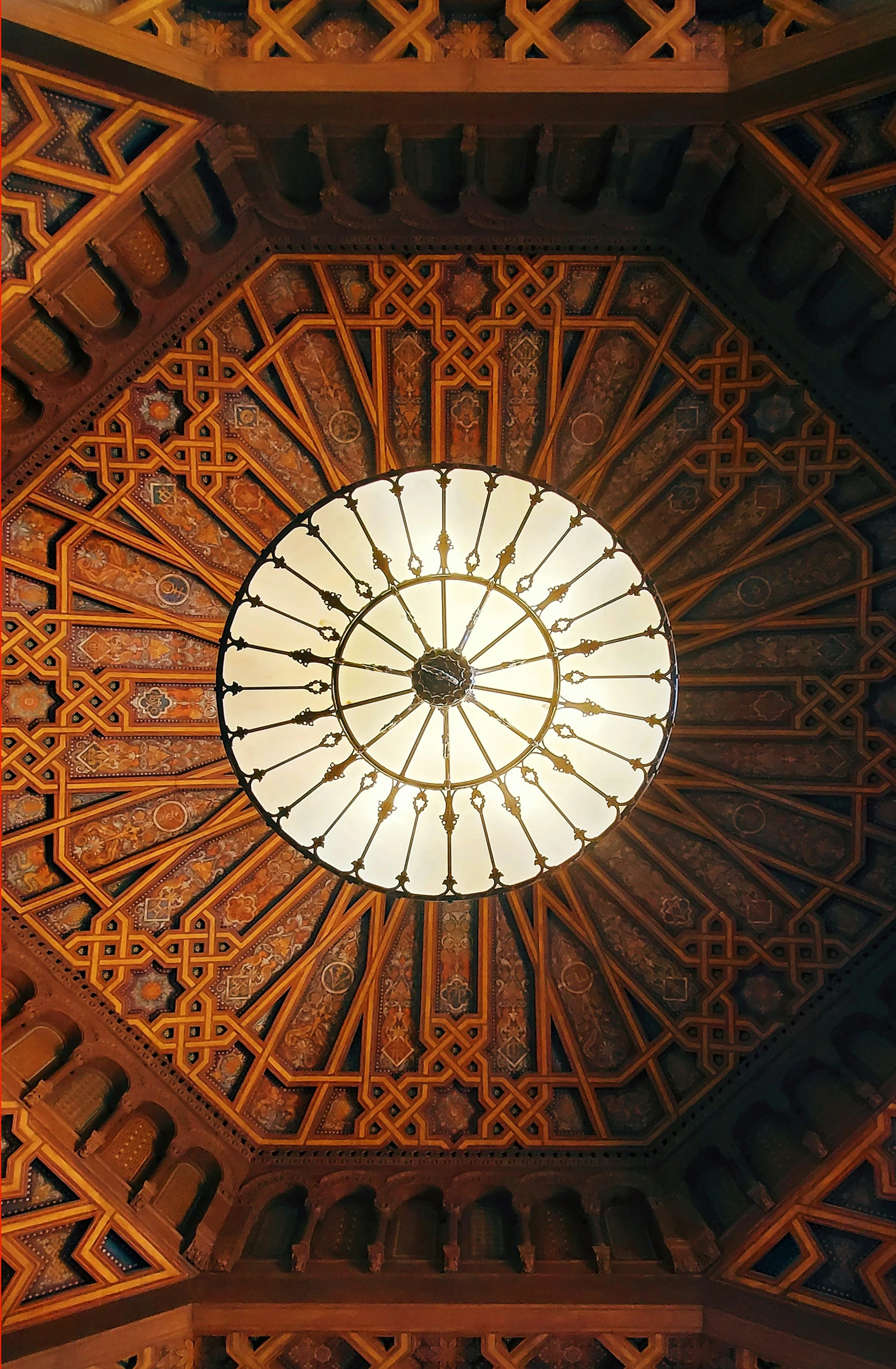 the large stained glass dome in the ceiling has intricate patterns