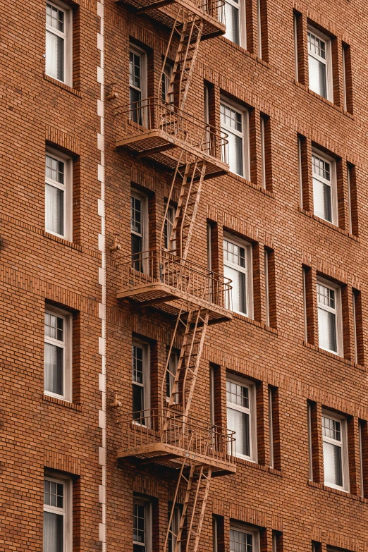 a tall brick building with many windows and a fire escape