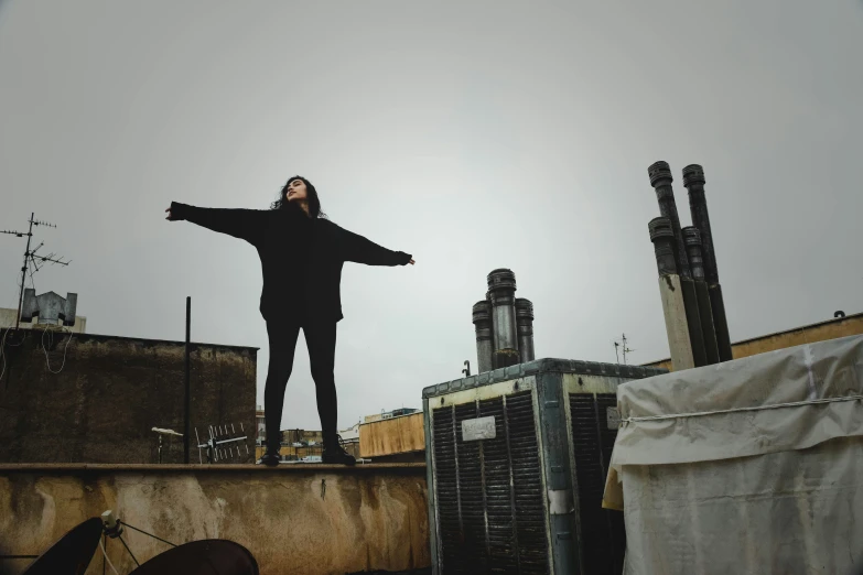 man standing on top of a roof while holding out his arms