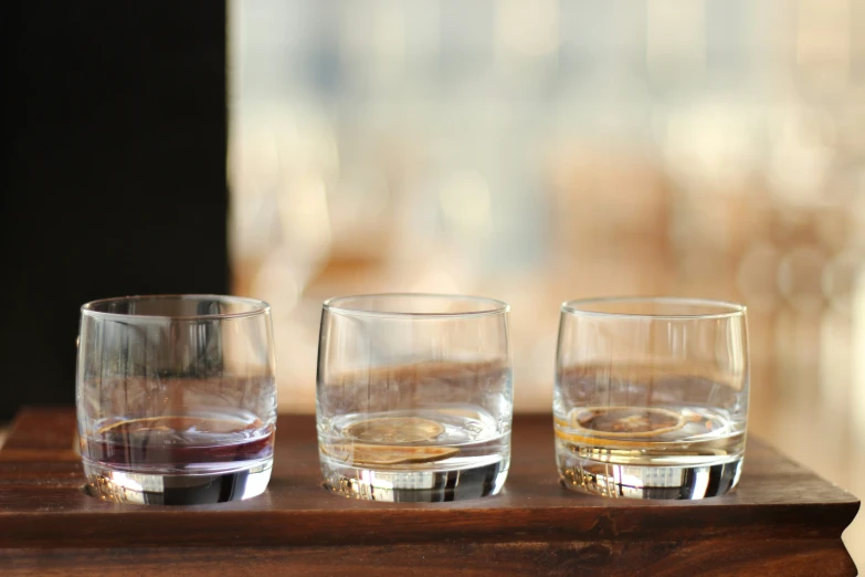 three glasses of different kinds of liquid on a tray