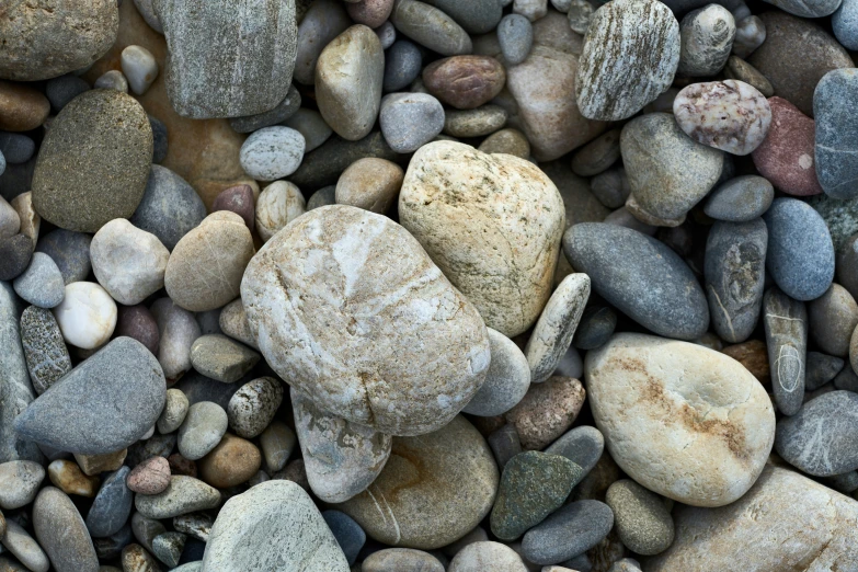 a pile of rocks in the sand with lots of rocks on it