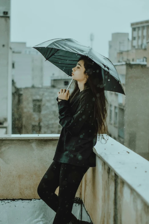 a woman wearing a black jacket holding an umbrella