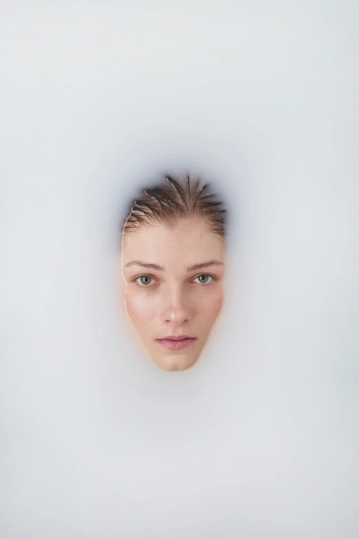 a woman's face is through the top half of a bubble