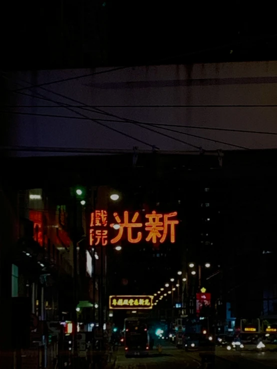 a street at night with some signs above it