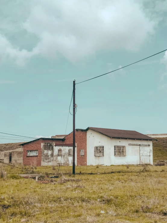 an old building in a field with power lines