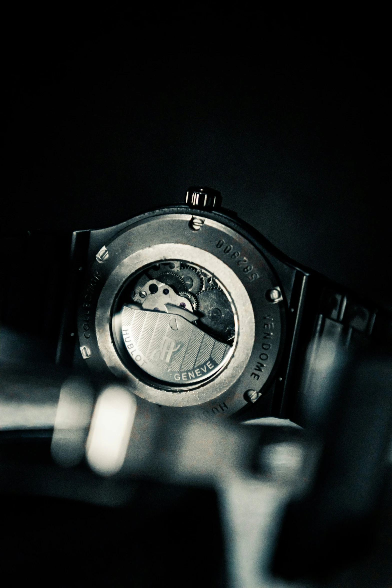 a close up of an automatic watch with a dark background