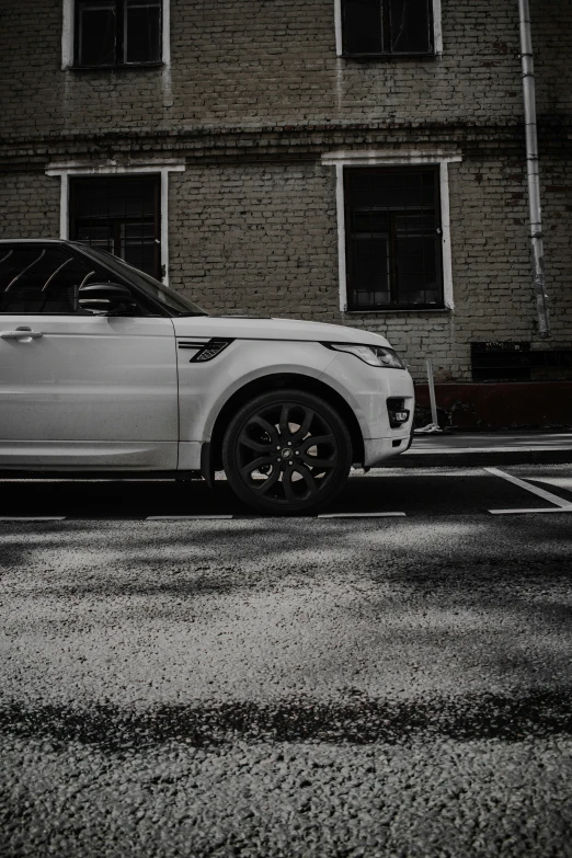 a white suv parked next to a brick building