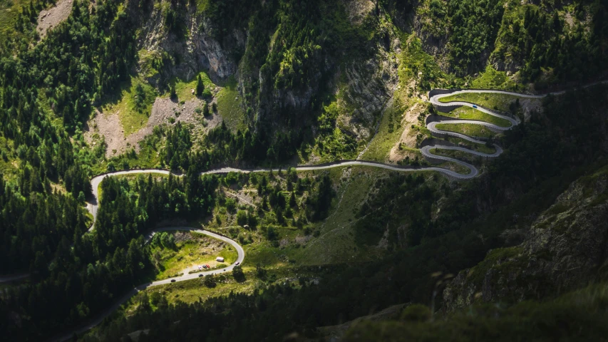 a winding mountain road with trees surrounding it