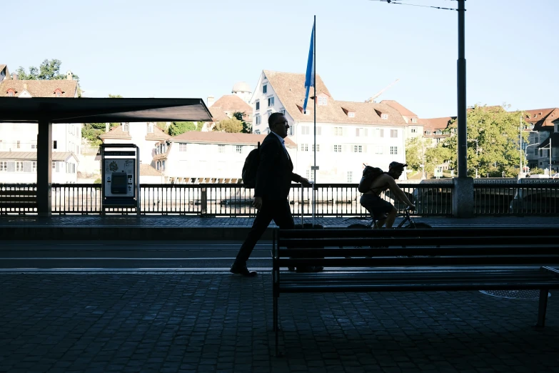 two men are walking down a bench by the street