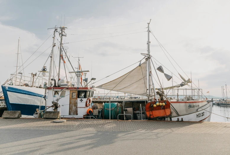 two boats are docked next to each other at a dock