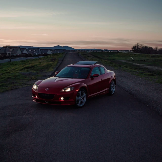 red sport car parked on road with sky in background