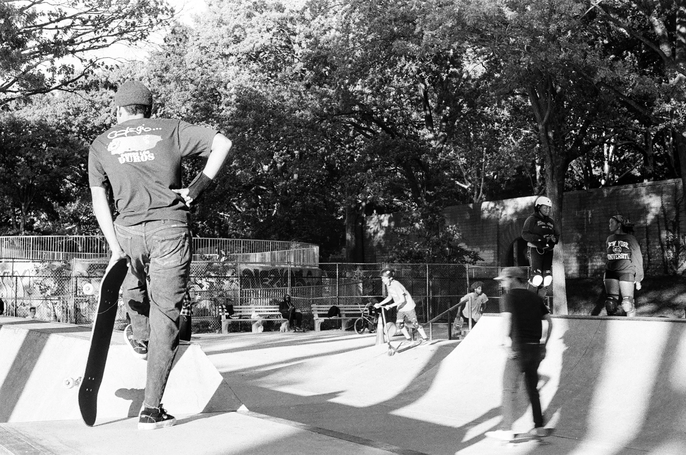 two skateboarders in an empty skate park with one trying to do a trick