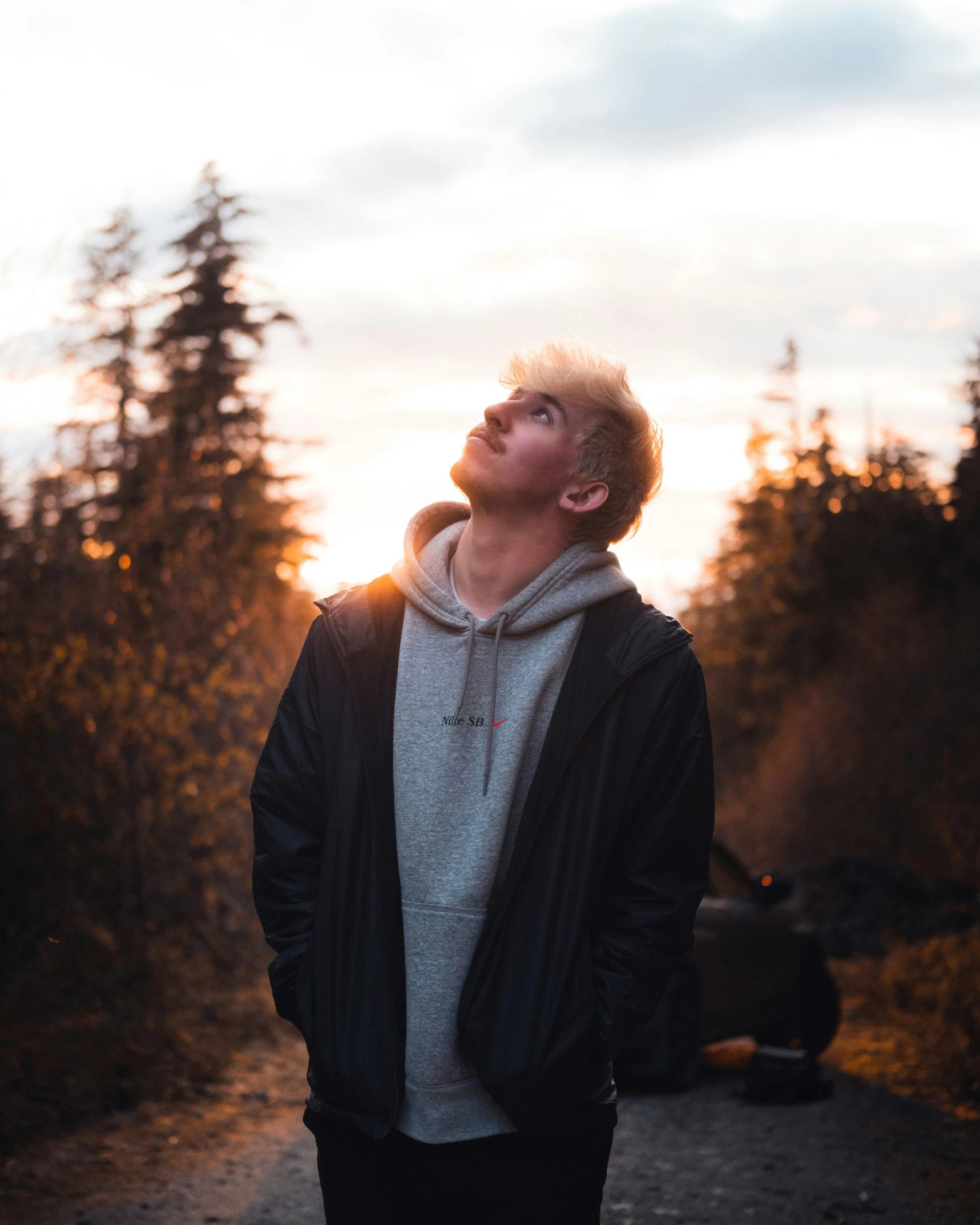 a man with headphones standing near a fire pit