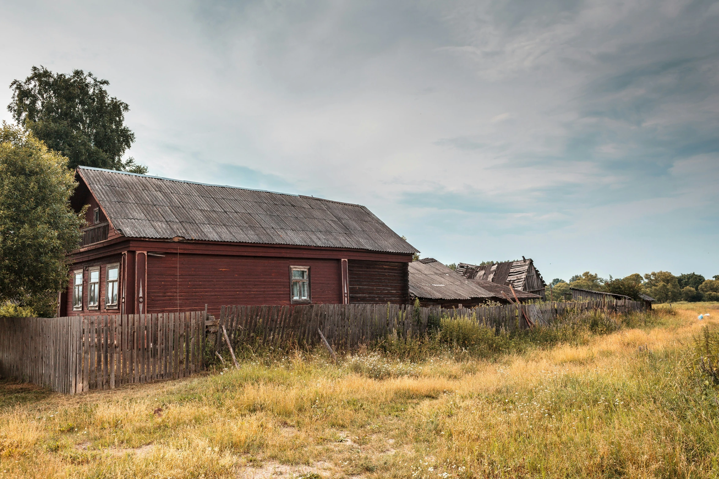 a farm with a wooden fence and a red barn