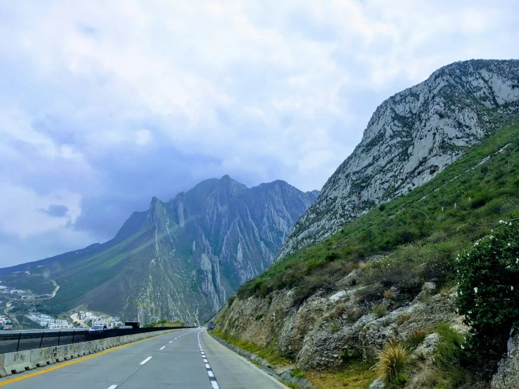 a view of mountains and mountains with cars driving on a freeway