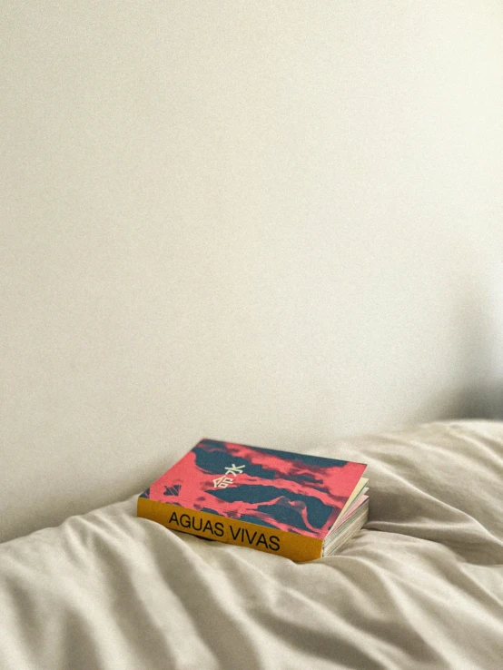 a yellow book sits on a white bed