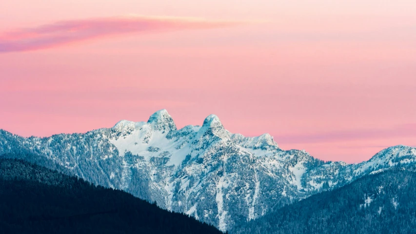 mountains covered in snow under a pink sky