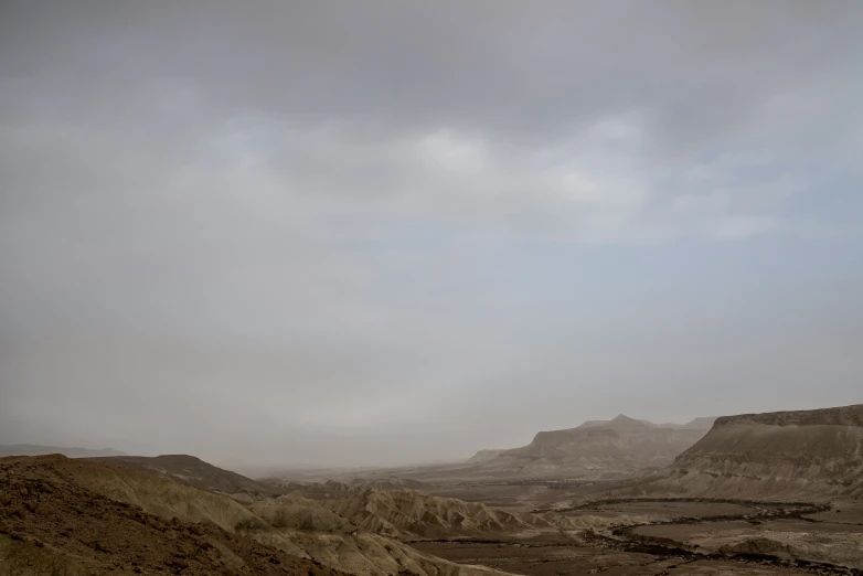 some hills and dirt with mountains in the distance