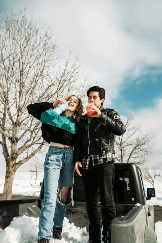 a couple drinking a red soda together in the snow