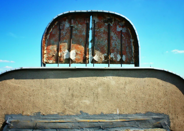 a rusty window on the side of a building with metal bars and rusty metal grates