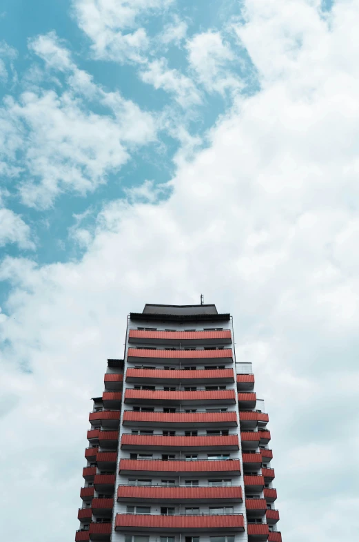 a tall building with an orange roof and red shutters