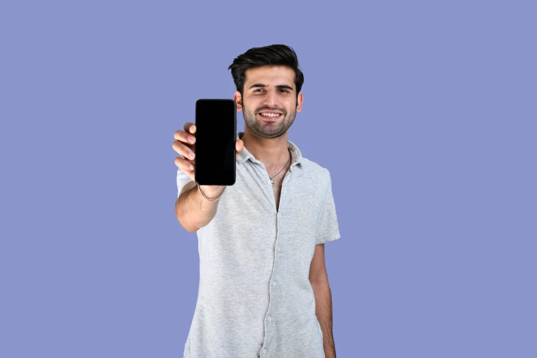 a young man holding up a black device