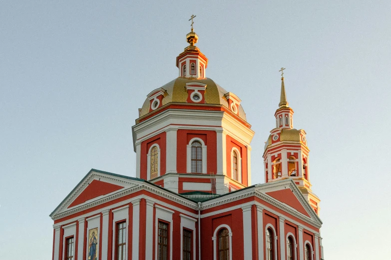 a red church with golden roofs on top