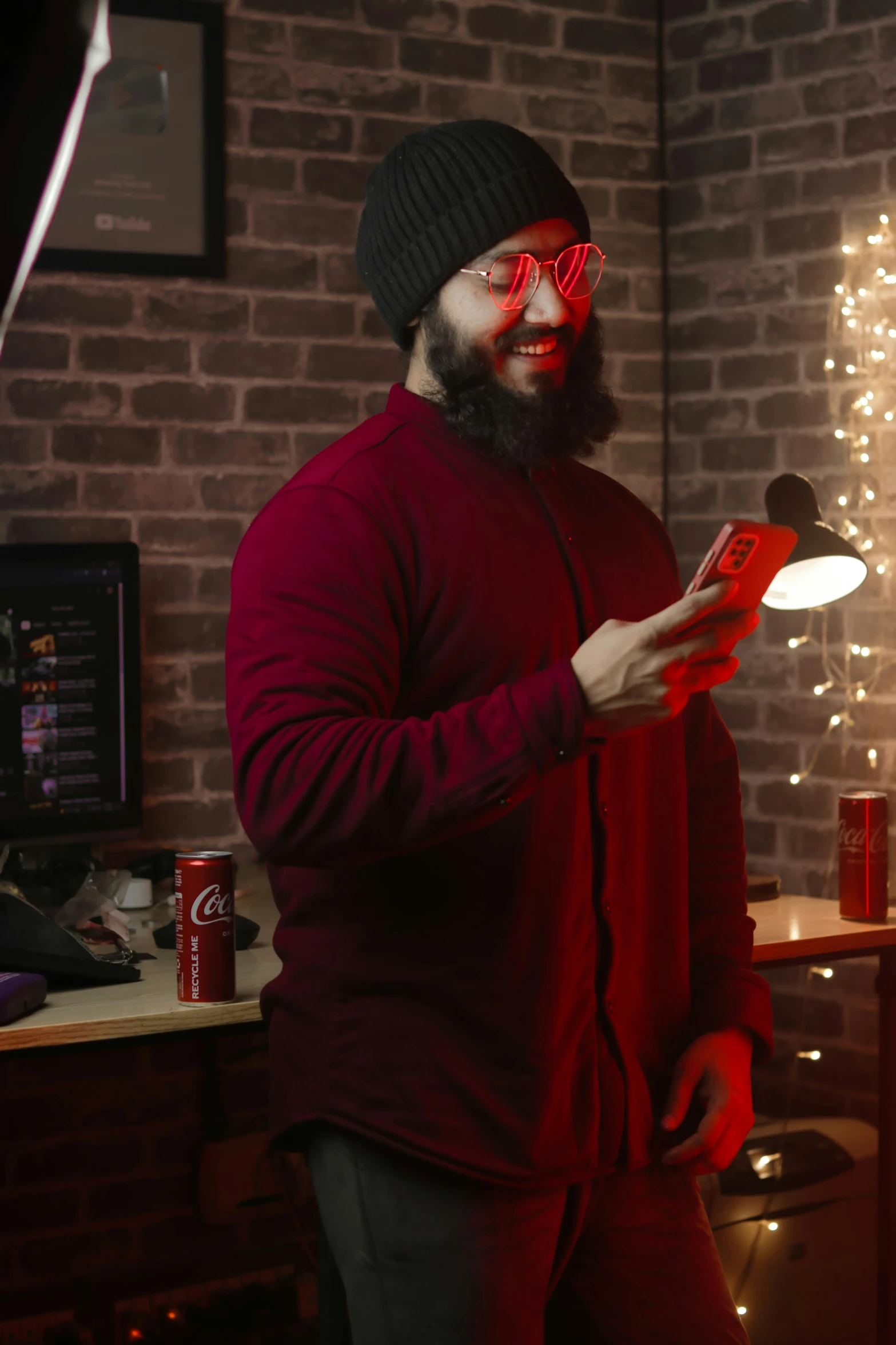 a man in a hat and glasses holding a phone