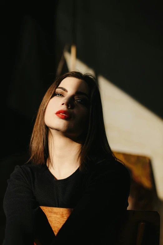 a woman that has her face partially closed on the end of a table