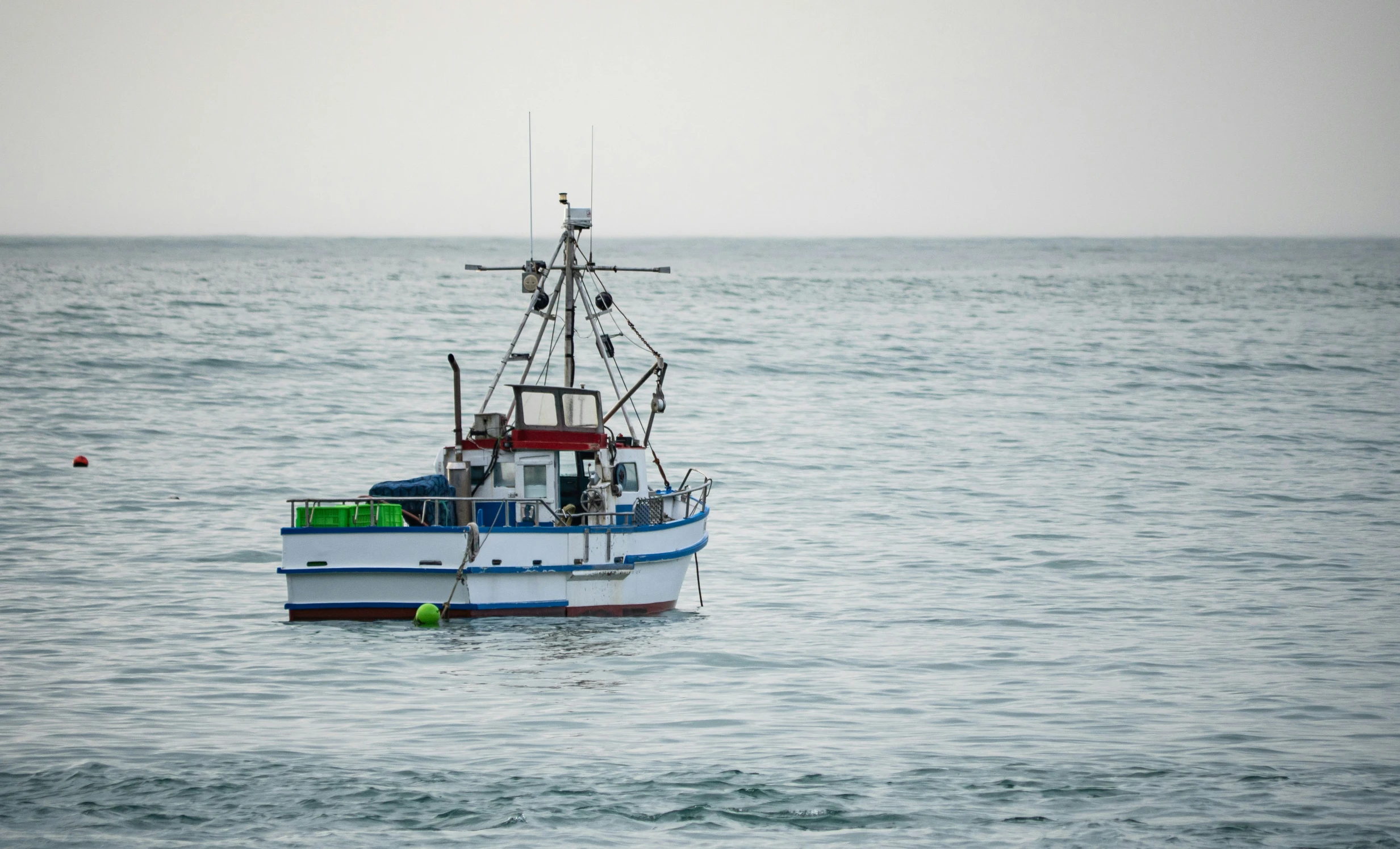 a small fishing boat in the middle of the ocean