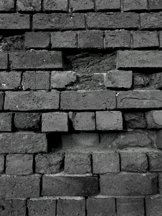 a black and white pograph of the side of a brick wall