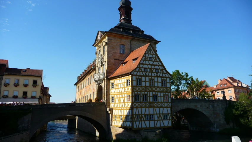 a building with an arch and two floors is beside a bridge
