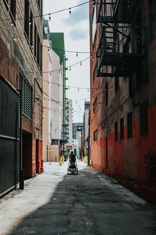 a person driving down an alley way with buildings on either side