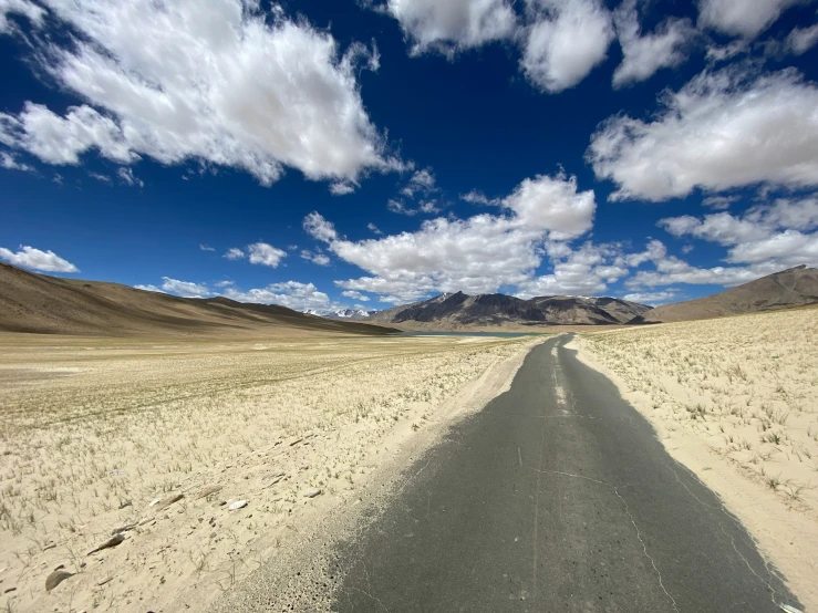 a long narrow dirt road running through an open plain