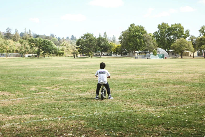 a boy standing in a field waiting on the frisbee