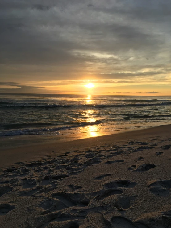 sunset on a sandy beach by the ocean