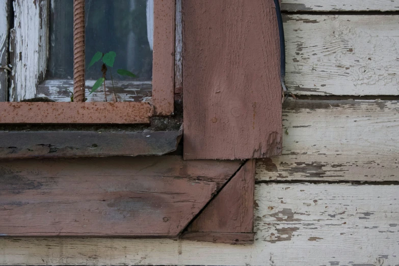 a window with rope hanging around the edges on the side of a house